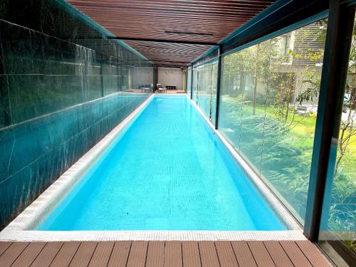 una piscina cubierta con una pared de cristal en Penthouse con la mejor vista de Cdmx, 6 personas, Gym y 2 parkings, en Ciudad de México