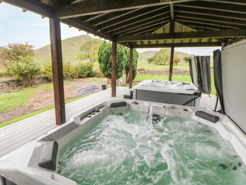 a jacuzzi tub on a deck with a view at Hillcrest House in Ashbourne