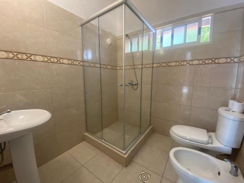 een badkamer met een douche, een toilet en een wastafel bij Hotel Select in Piriápolis