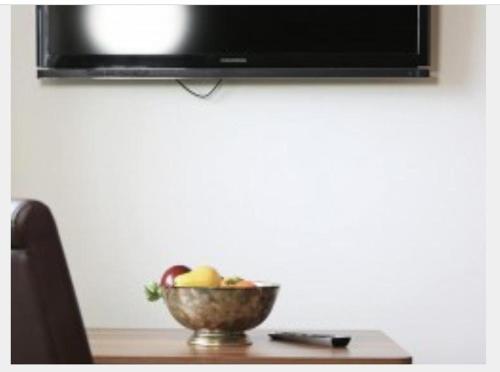 a bowl of fruit on a table with a television at L'Ulivo Italienische Restaurant und Pension in Pleiskirchen