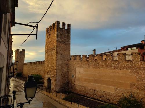 a large brick wall with a tall tower at Ca L'Aida Rural 2 in Montblanc