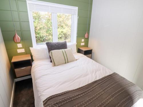 a small bedroom with a bed and a window at The Gallops in Chipping Norton