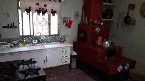 a kitchen with a sink and a counter and a window at Sitio Aguá Santa in Itapeva