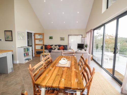 a kitchen and living room with a wooden table and chairs at The Lodge in Stranraer