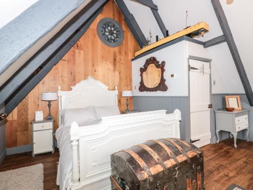 a bedroom with a white bed in a attic at Dancing Beggars in Dartmouth