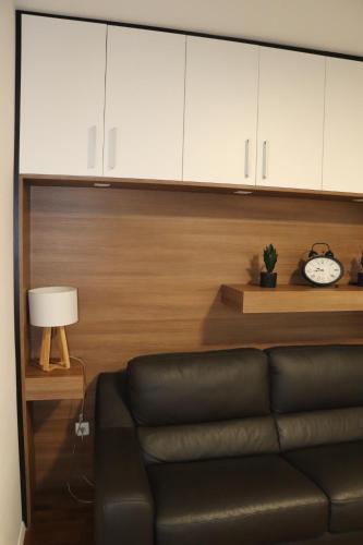 a living room with a couch and a clock at Studio apartma Terme Ptuj in Ptuj