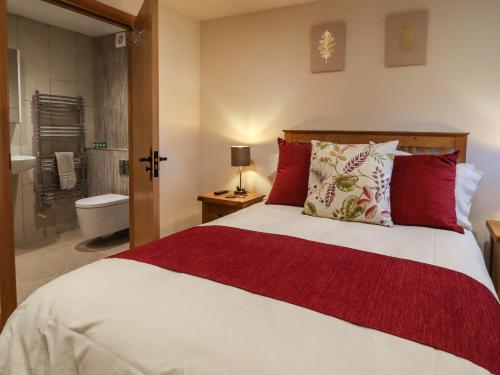 a bedroom with a bed and a bathroom with a tub at Mosscarr Barn in Harrogate