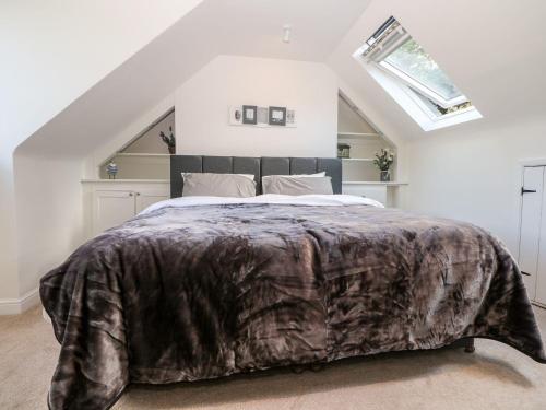 a bedroom with a large bed with a brown blanket at Bailey Cottage in Southampton