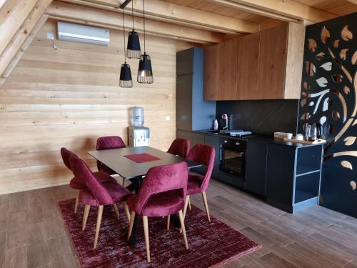 a kitchen with a table and purple chairs at Batllava Premium Resort Villa 7 in Orllan