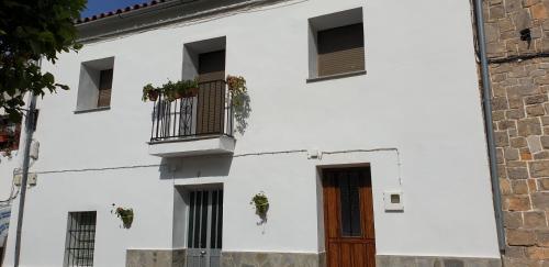 um edifício branco com janelas e uma porta em La Casa del Muro em El Bosque