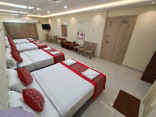 a group of four beds in a hotel room at Sri Aswin Grand in Nāmakkal