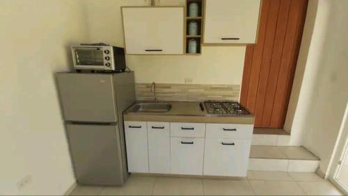 a small kitchen with a refrigerator and a microwave at One Happy Stay Santa Cruz - Casita in Santa Cruz