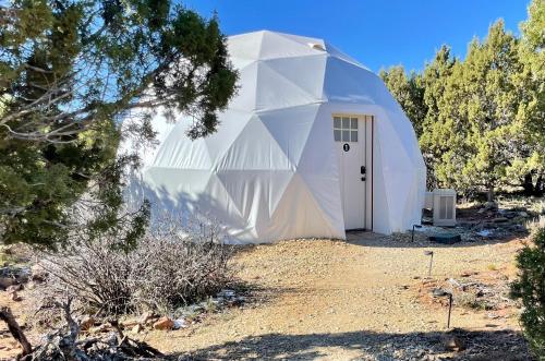 una gran casa blanca con una puerta en un campo en Blue Mountain Domes - The WOW Experience en Monticello
