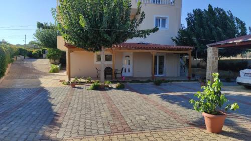 a small white house with a tree in front of it at Evelina's suite in Artemida