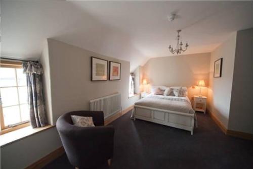 a bedroom with a bed and a chair at The Kingsdon Inn in Kingsdon