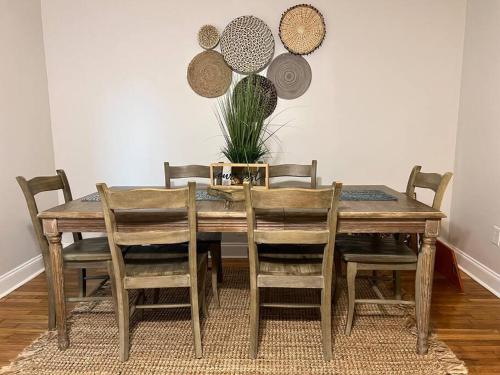 uma mesa de jantar em madeira com cadeiras e uma planta em Newly Renovated Historic Home Near Park Circle em Charleston