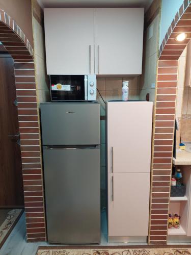 eine Küche mit 2 Kühlschränken und einer Mikrowelle in der Unterkunft 1st Apartment in Nehoiu
