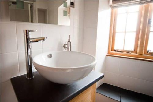 a bathroom with a large white bowl sink on a counter at The Kingsdon Inn in Kingsdon