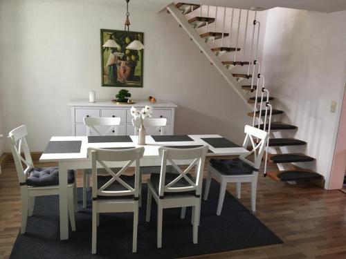 un comedor con mesa y sillas y una escalera en Schöne Große Wohnung, Terrasse, Kamin, Parkplatz, 2 Schlafzimmer en Greifswald