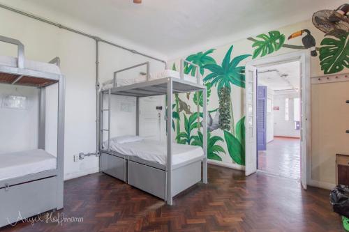 a bedroom with two bunk beds and a palm mural at Pura Vida Hostel in Rio de Janeiro