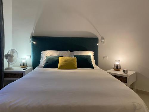 a bedroom with a large white bed with yellow pillows at Villa Gisele in Tamariu