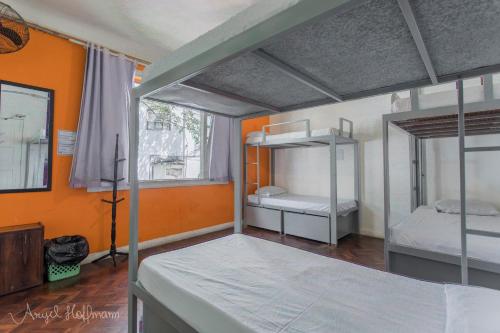 a bedroom with two bunk beds and an orange wall at Pura Vida Hostel in Rio de Janeiro