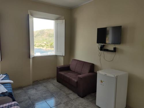 uma sala de estar com um sofá e uma televisão em Pousada Maria Bonita - Piranhas, Alagoas. em Piranhas