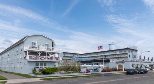 a large white building with an american flag in front of it at Grand Hotel Cape May in Cape May