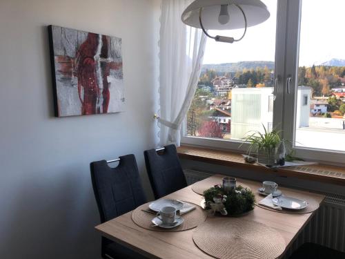 a dining room table with chairs and a large window at Sweet Dreams Wellness Appartement in Seefeld in Tirol