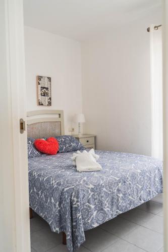 a bedroom with a bed and a red pillow on it at Benalbeach Sea Front in Benalmádena