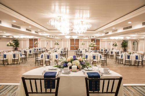 a banquet hall with tables and chairs and a chandelier at Grand Hotel Cape May in Cape May