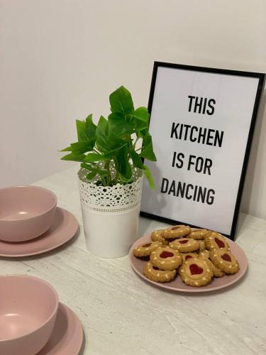 a plate of cookies on a table withthis kitchen is for dancing sign at Scandi Home in Uralsk