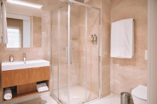 a bathroom with a shower and a sink at BFRESH Hotel - Padel, Pool & Fitness - Adults Only in Porto