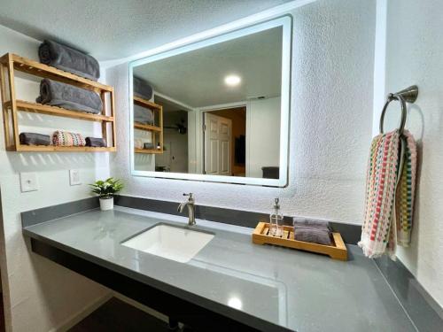 baño con lavabo y espejo grande en Quiet Remodeled 3 Bedroom in Heart of Downtown Sacramento en Sacramento