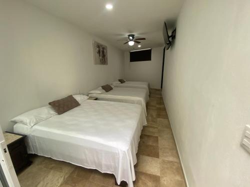 3 camas en una habitación con paredes blancas en Hotel fresno Xochitepec, en Chiconcuac