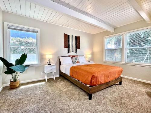 a bedroom with a bed and two windows at Uniquely styled home minutes to Downtown Sac! in West Sacramento