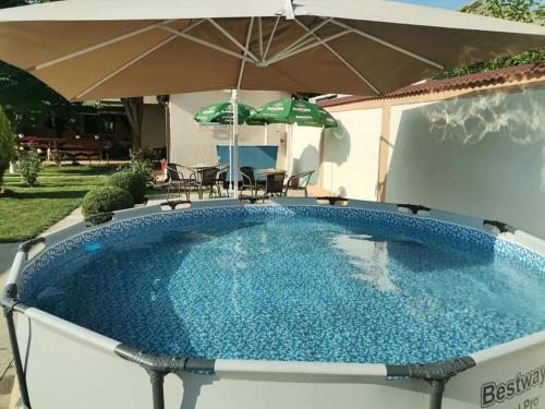 a large plunge pool with an umbrella and chairs at Casa Viviana in Baia