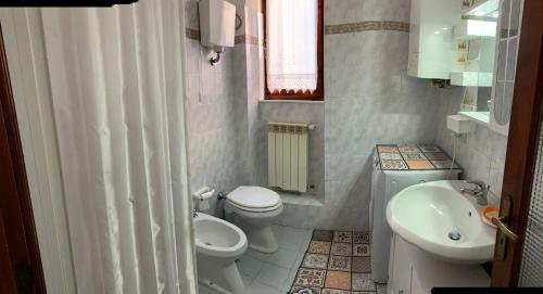 Baño pequeño con 2 aseos y lavamanos en La Casa dei Nonni, en Castagneto Carducci