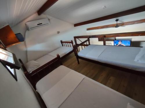 een kamer met 2 bedden aan het plafond bij Pousada Boto Mar in Garopaba