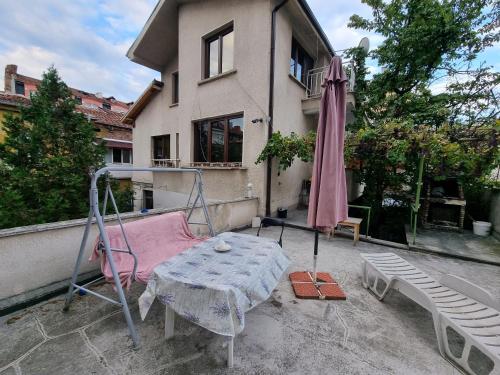 a patio with a table and an umbrella at Tsar Simeon, 2 bedroom, living room and fireplace in Sofia