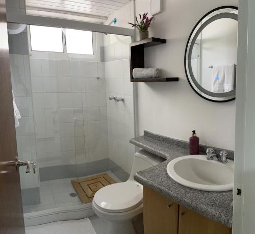 een badkamer met een wastafel, een toilet en een spiegel bij ¡Hermoso Apartamento en Loma Real! in Porlamar