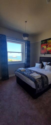 ein Schlafzimmer mit einem großen Bett und einem Fenster in der Unterkunft Alexandra Hotel in Eastbourne