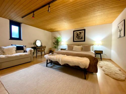 a bedroom with a large bed and a couch at Beautiful Chalet on the piste in Swiss Alps in Alt Sankt Johann