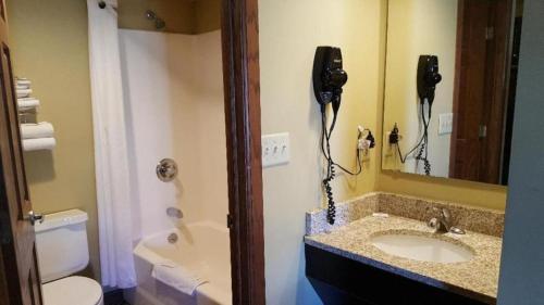 ein Badezimmer mit einem Waschbecken und einem Telefon an der Wand in der Unterkunft Jackson Town House Inn in Jackson