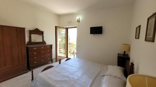 een slaapkamer met een bed, een dressoir en een televisie bij Agriturismo Poggio la Lodola in Massa Marittima