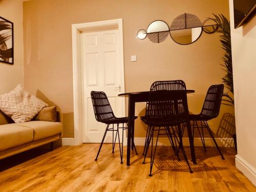 uma mesa de jantar com cadeiras e um sofá em 'Afton' at stayBOOM em Lancaster