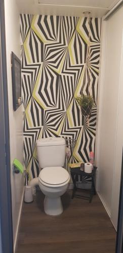uma casa de banho com WC e papel de parede geométrico em Chez Marie Laure em Nogent-le-Rotrou