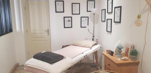 una camera ospedaliera con un letto e immagini appese al muro di Chez Marie Laure a Nogent-le-Rotrou