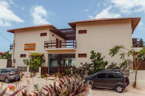a house with two cars parked in front of it at Casa Naná - Suites in Prea