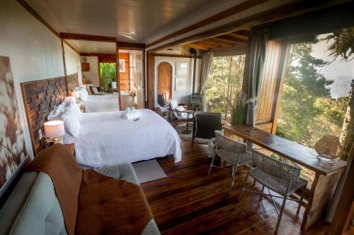 a bedroom with a bed and a room with a view at IL Rifugio Cabanas in Urubici